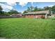 Expansive backyard with healthy green grass, a brick house, and shady trees at 6233 Castlewood Dr, Morrow, GA 30260