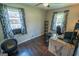 Bright bedroom featuring hardwood floors, ceiling fan, and blue curtains at 6233 Castlewood Dr, Morrow, GA 30260