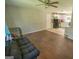 Open floor plan featuring a living room, hardwood floors, ceiling fan, and white cabinets in the kitchen at 6233 Castlewood Dr, Morrow, GA 30260