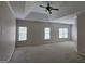 Spacious carpeted bedroom with multiple windows, a ceiling fan, and neutral paint at 7235 Thoreau Cir, Atlanta, GA 30349