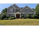 Charming brick home featuring a manicured lawn, symmetrical design, and a welcoming double-door entrance at 7235 Thoreau Cir, Atlanta, GA 30349