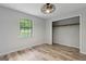 Bright bedroom features a ceiling fan, wood-look flooring, a window, and a closet at 147 Pine St, Covington, GA 30014