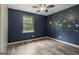This bedroom features hardwood-style flooring and custom space themed wall decor at 147 Pine St, Covington, GA 30014