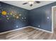 This bedroom features hardwood-style flooring and custom space themed wall decor at 147 Pine St, Covington, GA 30014