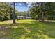 Peaceful residence surrounded by lush greenery and mature trees on an expansive lawn at 147 Pine St, Covington, GA 30014