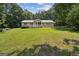 Traditional home with a well-manicured lawn, mature trees, and inviting front porch at 147 Pine St, Covington, GA 30014