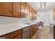Functional kitchen with classic wood cabinets, white countertop and stainless steel dishwasher at 147 Pine St, Covington, GA 30014