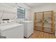 Bright laundry room with washer, dryer, shelves and window at 147 Pine St, Covington, GA 30014