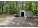 Metal shed in a wooded area with gravel ground, offering storage space at 147 Pine St, Covington, GA 30014