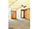 Spacious living room featuring carpeting, wood paneling, and a ceiling fan with light fixture at 398 Mckenzie Dr, Stockbridge, GA 30281