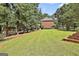 Expansive green backyard with a brick home, surrounded by mature trees and a pristine lawn at 100 Old Plantation Way, Fayetteville, GA 30214