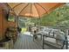 Large covered deck area with fireplace, grill, wood pile and comfortable outdoor seating at 100 Old Plantation Way, Fayetteville, GA 30214
