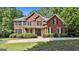 Charming two-story brick home featuring a manicured lawn and inviting front porch at 100 Old Plantation Way, Fayetteville, GA 30214