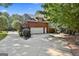 Brick garage with a white door and extended driveway surrounded by trees at 100 Old Plantation Way, Fayetteville, GA 30214