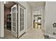 Hallway leading to the media room with Peloton, a bar area, and double glass doors at 100 Old Plantation Way, Fayetteville, GA 30214