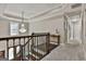 Upstairs hallway with chandelier, dark wood banister, and view of front door at 100 Old Plantation Way, Fayetteville, GA 30214
