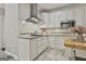 Modern kitchen with stainless steel hood, granite countertops, and ample cabinet space for storage at 100 Old Plantation Way, Fayetteville, GA 30214