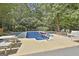 Backyard pool is surrounded by lush greenery and plenty of lounge area at 100 Old Plantation Way, Fayetteville, GA 30214