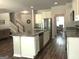 Open concept kitchen featuring granite countertops, stainless steel appliances, and a view of the living area and stairwell at 85 Crabapple Ridge Dr, Oxford, GA 30054