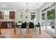 Contemporary dining area connects kitchen and back porch, featuring glass table and modern lighting at 48 Star Spangled Ln, Peachtree City, GA 30269