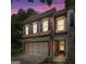 Charming two-story brick home featuring black shutters, a two-car garage, and manicured front yard at twilight at 48 Star Spangled Ln, Peachtree City, GA 30269