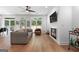 Open-concept living room featuring hardwood floors, a ceiling fan, and a cozy fireplace at 48 Star Spangled Ln, Peachtree City, GA 30269
