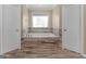 Bright bathroom with a soaking tub, tiled surround, and double doors at 200 Magnolia Ct, Mcdonough, GA 30252