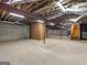 Unfinished basement featuring exposed beams, concrete floor, and brick accent wall at 95 Fern Ct, Stockbridge, GA 30281