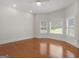 Spacious bedroom with hardwood floors, a ceiling fan, and multiple windows providing natural light at 95 Fern Ct, Stockbridge, GA 30281