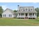 Charming two-story home with a large front porch, white siding, dormer windows, and mature landscaping at 2110 Mcgarity Rd, Mcdonough, GA 30252