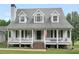Lovely two-story home featuring a welcoming front porch, dormer windows, and an American flag at 2110 Mcgarity Rd, Mcdonough, GA 30252