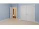 Bedroom featuring light blue walls, carpet, white closet doors, and natural lighting at 5297 Heron Bay Blvd, Locust Grove, GA 30248