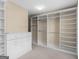 Spacious walk-in closet featuring custom shelving and storage, and white cabinetry for organizing clothes and accessories at 5297 Heron Bay Blvd, Locust Grove, GA 30248