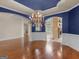 Open-concept room boasts hardwood floors, blue accent walls, and an elegant chandelier at 5297 Heron Bay Blvd, Locust Grove, GA 30248