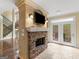 Bright living room includes a stone fireplace with mounted TV and stairs leading to the second floor at 5297 Heron Bay Blvd, Locust Grove, GA 30248