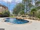 Inviting backyard pool with rock waterfall feature, surrounded by lush landscaping and mature trees at 5297 Heron Bay Blvd, Locust Grove, GA 30248
