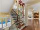 Grand staircase with iron railings and hardwood steps, bright windows, and view of pool, living room, and kitchen at 5297 Heron Bay Blvd, Locust Grove, GA 30248