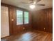 Bedroom with wood paneling, hardwood floors, and windows offering a view of the outdoors at 8833 Thomas Rd, Jonesboro, GA 30238