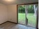 This room features grey laminate flooring with white walls, and large glass sliding doors looking out to the lush green lawn at 8833 Thomas Rd, Jonesboro, GA 30238