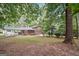 Spacious backyard featuring a covered patio, mature trees, and lush greenery at 954 Camp Creek Sw Dr, Lilburn, GA 30047