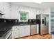 Bright kitchen with white cabinets, stainless appliances, and black granite countertops at 954 Camp Creek Sw Dr, Lilburn, GA 30047