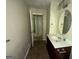 Bathroom with a single sink vanity, an oval mirror, and neutral walls leading to the doorway at 3144 Clemons Rd, Stockbridge, GA 30281