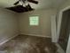 The bedroom in need of repair has a damaged ceiling with exposed wood and a window overlooking the backyard at 3144 Clemons Rd, Stockbridge, GA 30281
