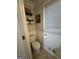 Cozy half-bathroom with wainscoting, window, and a stylish toilet and wall shelves at 375 Big Game Way, Loganville, GA 30052