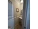 Compact half-bathroom featuring wainscoting, pedestal sink, mirror, and framed decor at 375 Big Game Way, Loganville, GA 30052