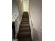 Carpeted staircase with white railings leads to the upper level of the home at 375 Big Game Way, Loganville, GA 30052
