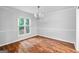 Bright dining room with hardwood floors, modern light fixture, and natural light from the window at 32 Ivy Ne Pkwy, Atlanta, GA 30342