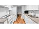Efficient kitchen features white cabinetry, subway tile backsplash, and stainless sink with wood flooring at 32 Ivy Ne Pkwy, Atlanta, GA 30342