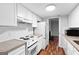 Modern kitchen with white appliances, granite counters, and white cabinets with view to living room at 32 Ivy Ne Pkwy, Atlanta, GA 30342