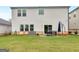 A flat backyard with patio area, table and chairs, and view of the home's exterior at 168 Warbler Way, Mcdonough, GA 30253
